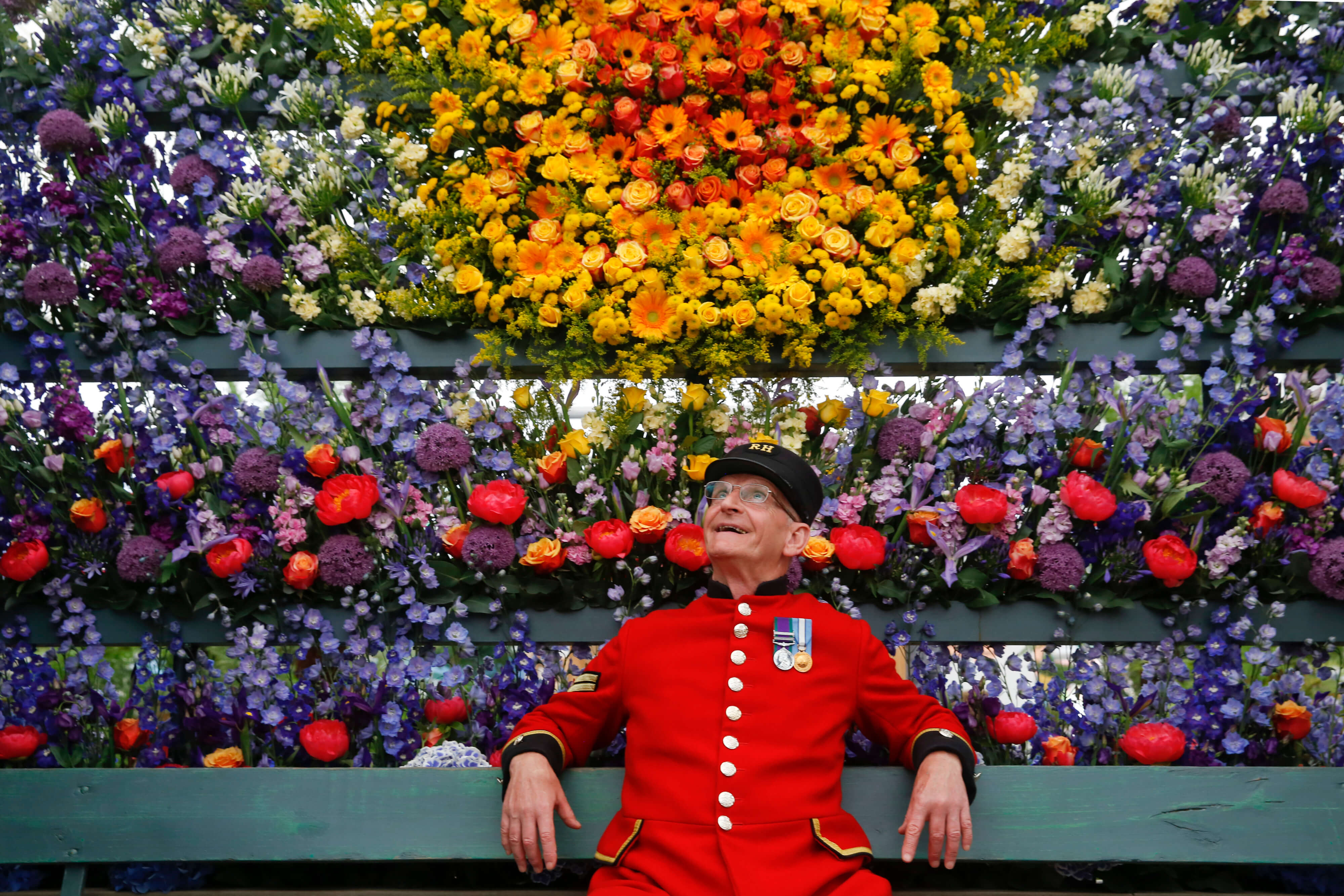 Man with background of flowers at the Chelsea Flower Show in London